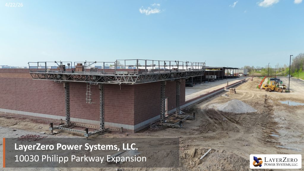 LayerZero Power Systems expansion end wall under construction with elevated masonry platform and site grading