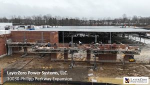 Front view of the LayerZero Power Systems Philipp Parkway expansion with steel structure, masonry walls, and active site work.