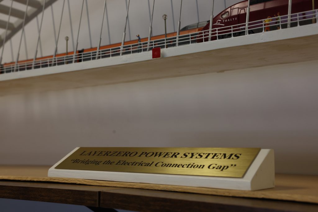 LayerZero Power Systems plaque displaying Bridging the Electrical Connection Gap beneath bridge model