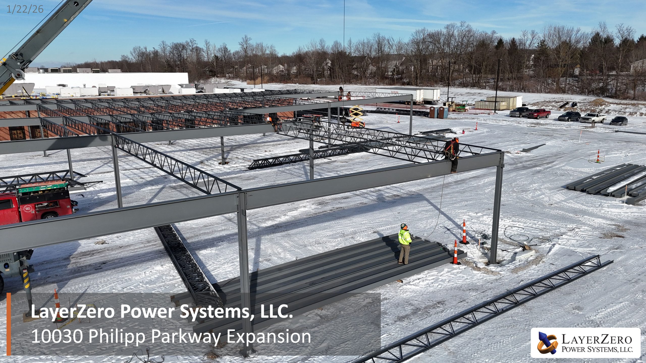 Crane lifting structural steel during construction of the LayerZero Power Systems 10030 Philipp Parkway facility expansion in winter conditions.
