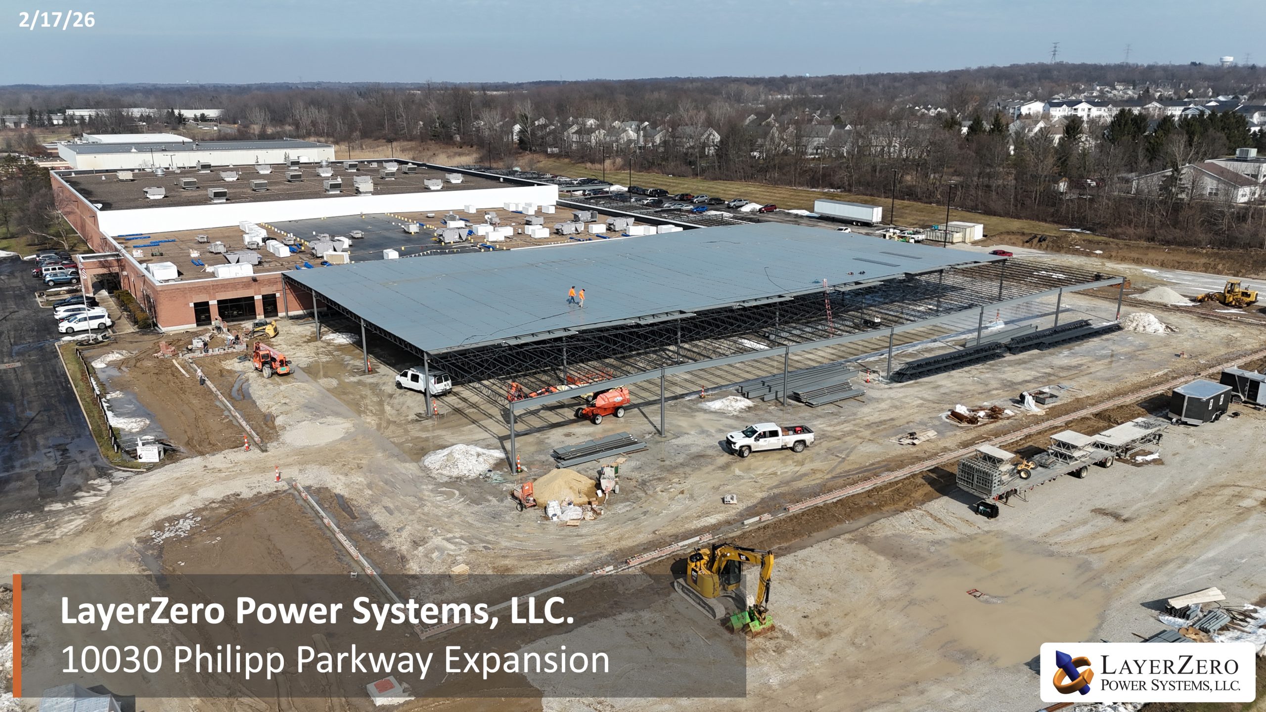 Wide aerial view of LayerZero Power Systems, LLC Philipp Parkway expansion showing completed roof sections and ongoing construction activity