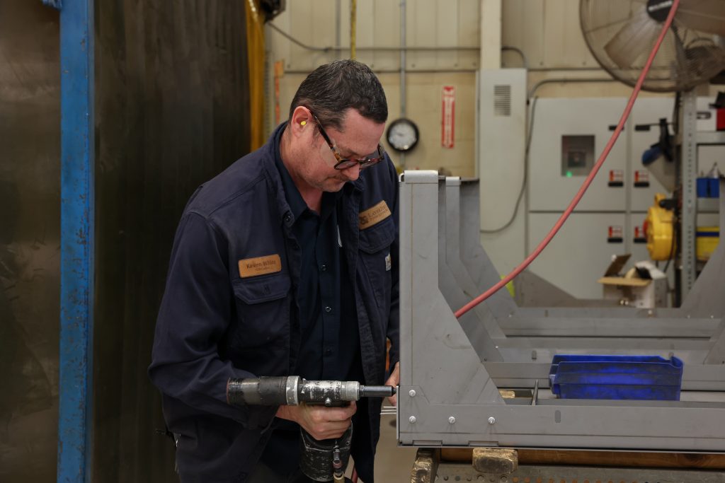 LayerZero Power Systems manufacturing technician assembling sheet metal enclosure in production facility