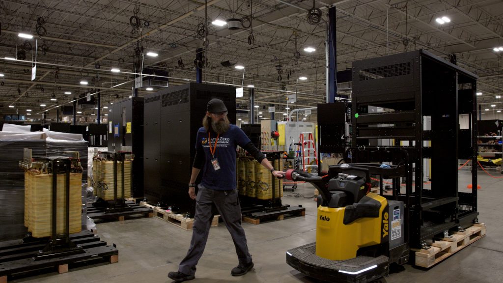Manufacturing floor with power equipment cabinets and material handling in progress.