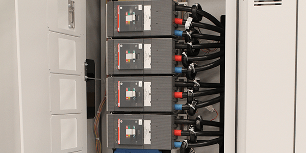 Vertical stack of molded-case subfeed circuit breakers with rear cable terminations inside mission-critical power distribution equipment