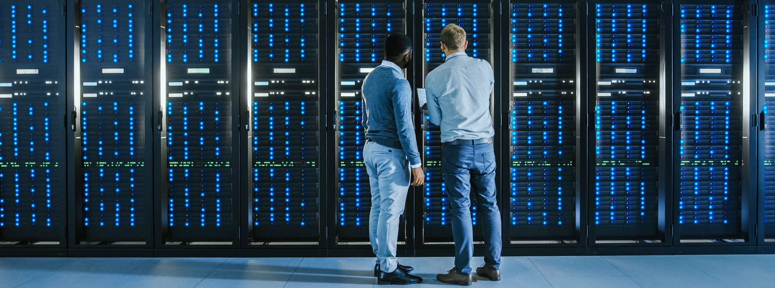 Data center engineers monitoring server racks in a mission-critical facility requiring continuous, redundant power